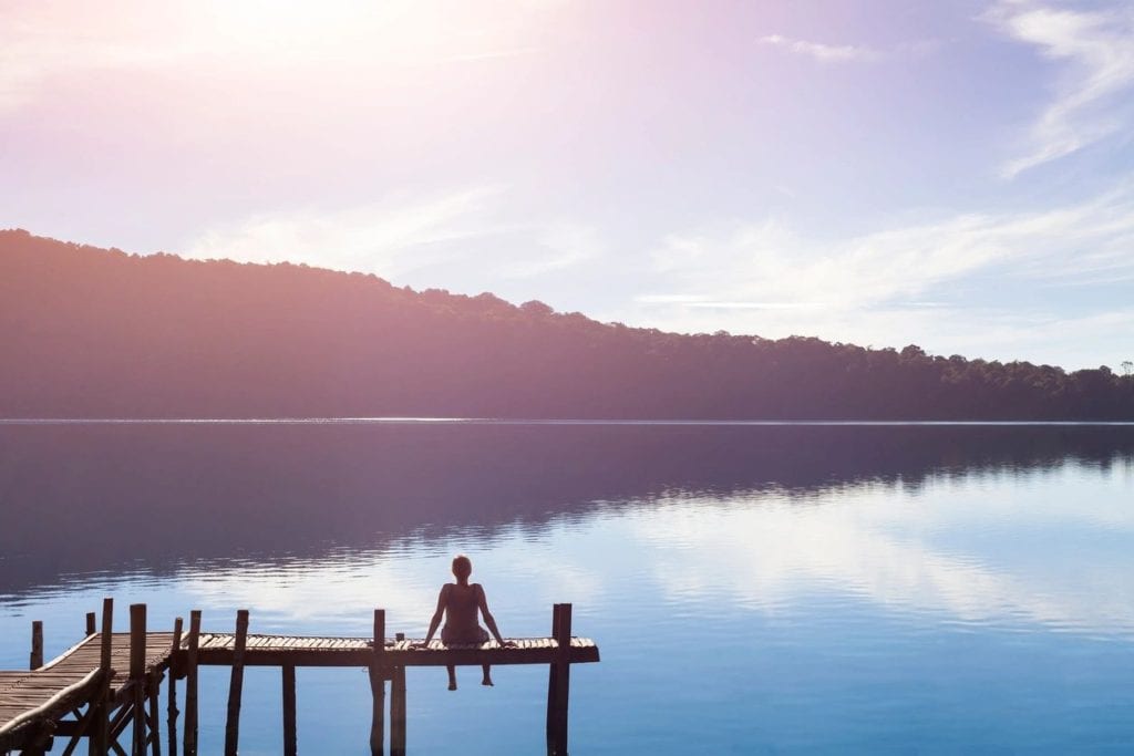 woman sitting on docks overlooking lake 2