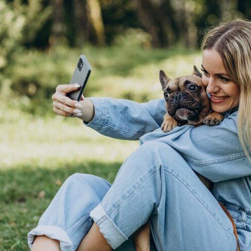 girl cuddling dog Capturing Instagram worthy pet pictures, a girl smiling hugging a dog